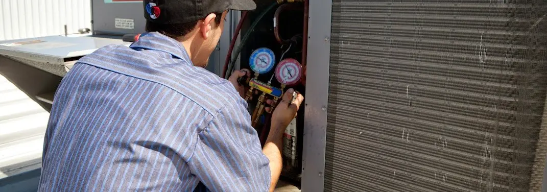HVAC technician servicing a condenser unit in Saddlebrooke