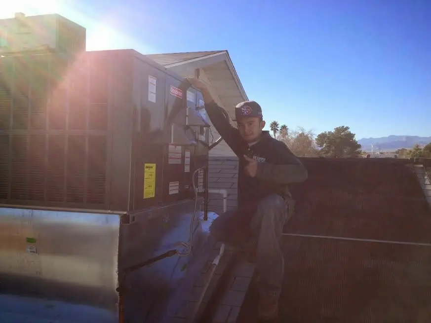 HVAC technician performing AC Tune-Up on a rooftop unit in Saddlebrooke